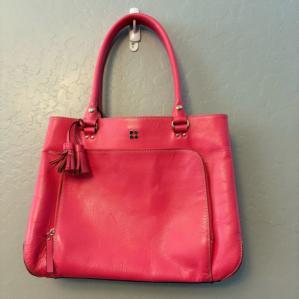 Kate Spade bright coral pink colored tote bag with snap closure and tassels
